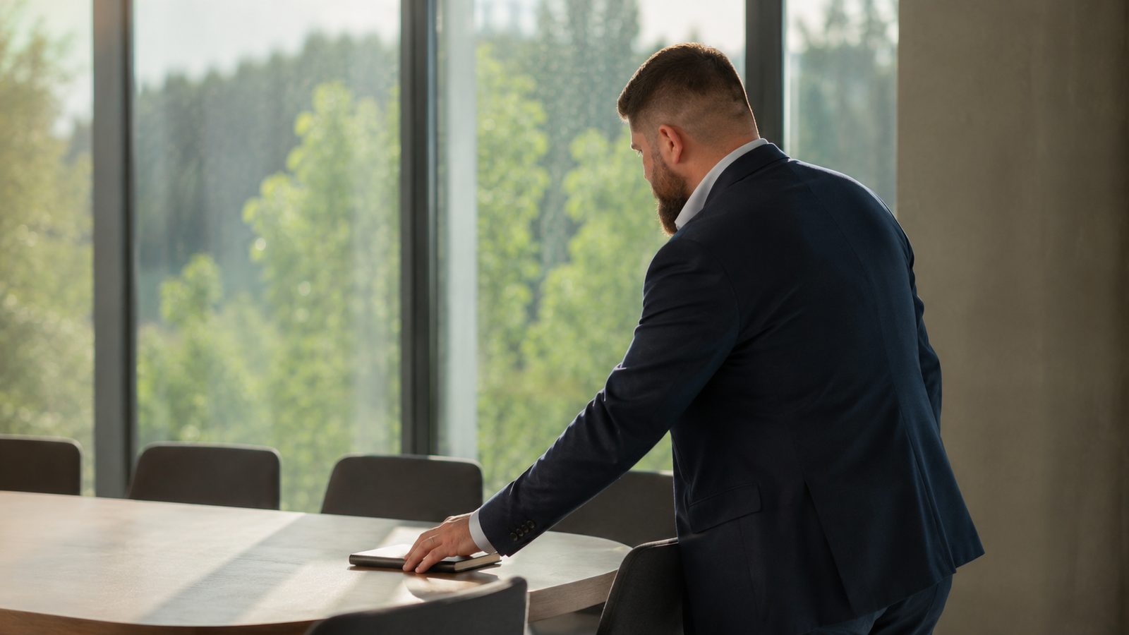 Artem Senik steht am Besprechungstisch und richtet den Blick auf die bereitgelegten Unterlagen